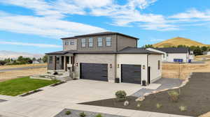 View of front of home with a mountain view and a garage