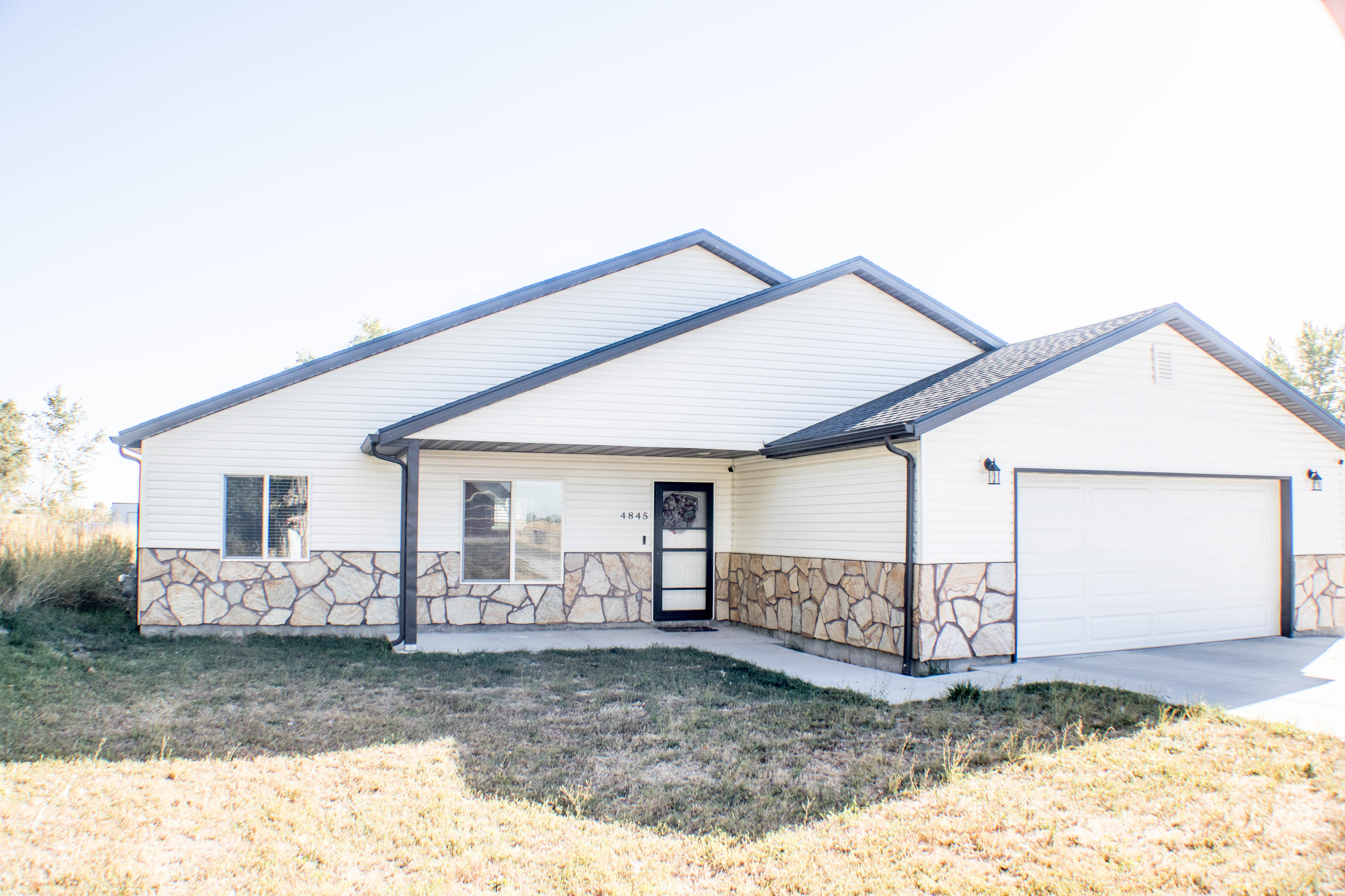 View of front of property featuring a garage and a front yard