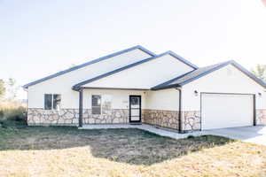 View of front of property featuring a garage and a front yard