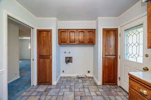 Washroom featuring hookup for a washing machine, cabinets, crown molding, and electric dryer hookup