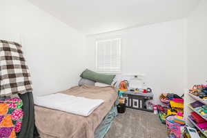 Carpeted bedroom with a wall mounted AC