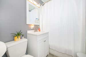 Full bathroom with shower / bath combination with curtain, vanity, and toilet