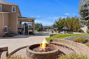 View of property's community with a swimming pool, a patio, and a fire pit