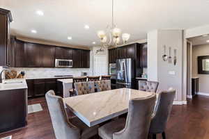 Dining room featuring a chandelier, dark wood-type flooring, and sink