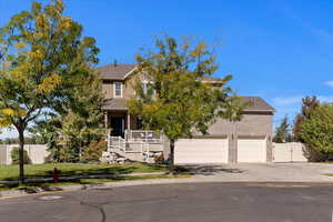 Obstructed view of property featuring a garage, a porch, and a front lawn