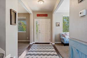 Entryway with a textured ceiling, hardwood / wood-style flooring, crown molding, and plenty of natural light