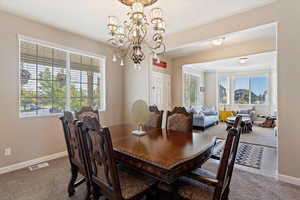 Dining space featuring a notable chandelier, carpet, and a wealth of natural light