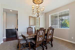 Dining space with dark carpet and a chandelier