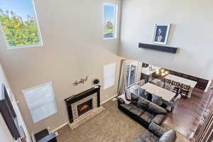 Living room featuring carpet floors, a high ceiling, and a brick fireplace