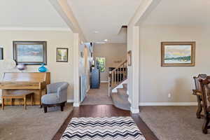 Foyer entrance featuring ornamental molding and dark wood-type flooring