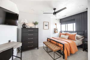 Carpeted bedroom featuring ceiling fan and a textured ceiling