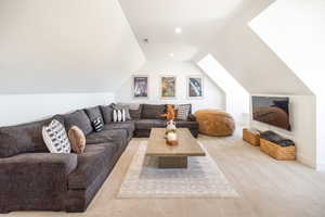 Carpeted living room with lofted ceiling