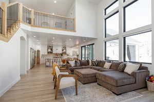 Living room featuring a towering ceiling and light hardwood / wood-style floors