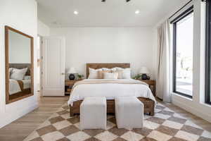 Bedroom with light hardwood / wood-style flooring and multiple windows