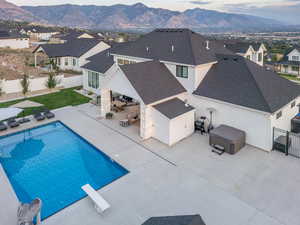 View of swimming pool with a diving board, a mountain view, and a patio area