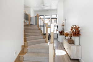 Staircase with wood-type flooring and ceiling fan