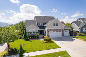 Craftsman-style house featuring a mountain view, a front yard, and a garage