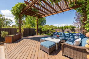 Wooden terrace featuring outdoor lounge area and a pergola