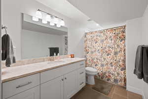 Bathroom featuring vanity, a textured ceiling, tile patterned flooring, toilet, and a shower with curtain