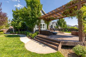 Wooden terrace featuring an outdoor living space, a pergola, a patio area, and a lawn