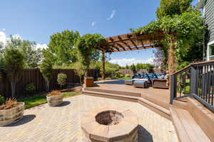 View of patio featuring an outdoor living space with a fire pit and a wooden deck