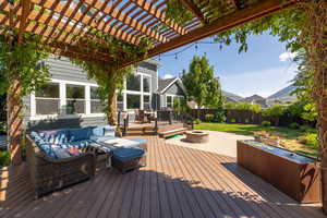 Wooden terrace with a pergola and an outdoor living space with a fire pit