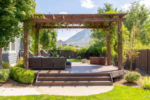 View of patio with a pergola, an outdoor living space, and a deck with mountain view