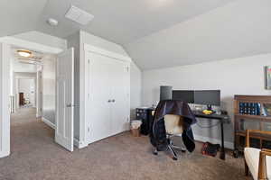 Office space featuring lofted ceiling, a textured ceiling, and carpet flooring