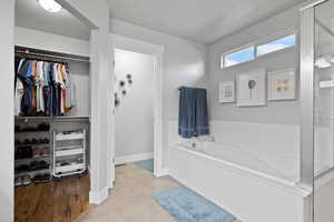Bathroom featuring a textured ceiling, plus walk in shower, and tile patterned floors