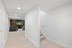 Hall with light carpet and wood walls