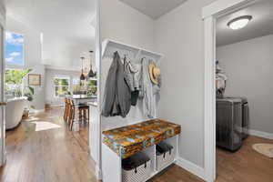 Mudroom with a textured ceiling, washing machine and dryer, and hardwood / wood-style floors