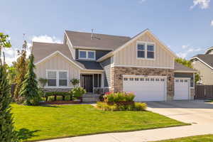 Craftsman-style house featuring a garage and a front lawn