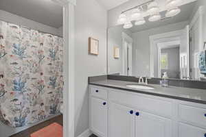 Bathroom with tile patterned flooring, a textured ceiling, vanity, and toilet