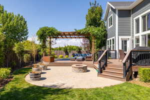 View of patio with a deck, an outdoor living space with a fire pit, and a grill