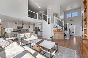Living room featuring a notable chandelier, a towering ceiling, and hardwood / wood-style floors
