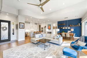 Living room with ceiling fan and light hardwood / wood-style flooring