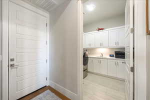 Clothes washing area featuring cabinets, sink, and washer / dryer