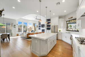 Kitchen with white cabinets, appliances with stainless steel finishes, plenty of natural light, and a kitchen island