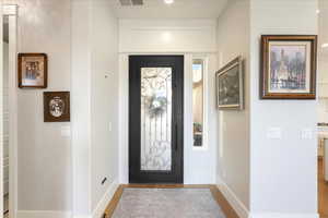 Entryway featuring ornamental molding and light hardwood / wood-style flooring