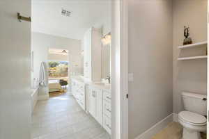 Bathroom featuring vanity, tile patterned flooring, and toilet