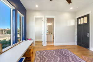 Entrance foyer with light wood-type flooring, ceiling fan, and plenty of natural light