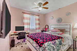 Bedroom with ceiling fan and light colored carpet