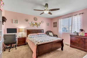 Carpeted bedroom featuring ceiling fan