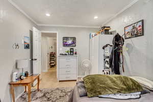 Bedroom featuring light tile patterned flooring and crown molding