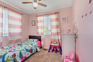 Carpeted bedroom featuring ceiling fan