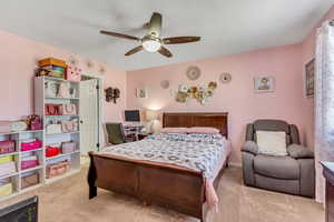 Carpeted bedroom featuring ceiling fan