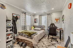 Bedroom with a textured ceiling and crown molding