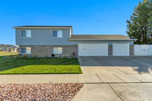 View of front of property featuring a front yard and a garage