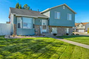 Split level home with a front lawn