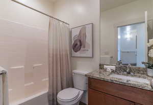 The hallway bathroom just outside the secondary bedrooms features a tub/shower, toilet, sink, oversized mirror and matching granite countertops.